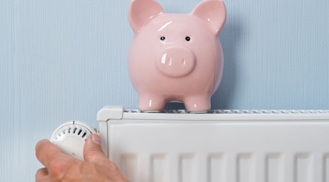 Ein Sparschwein steht auf einem Heizkörper und symbolisiert finanzielle Vorteile